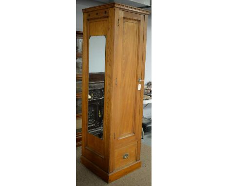 An early 20th Century maritime/railway walnut wardrobe, the plain panel door opening to reveal hanging space above a commode 