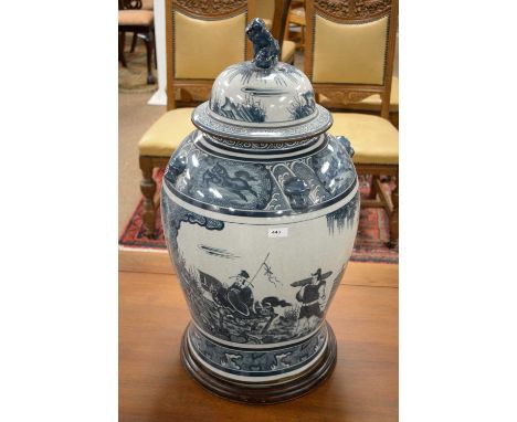 A 20th Century Chinese blue and white floor standing vase, the body painted with two panels of figures, Fo dog finial to the 