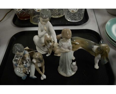 A collection of four Lladro figures, including: a figure group of a boy seated with dog and puppies, 12cms high; a figure of 