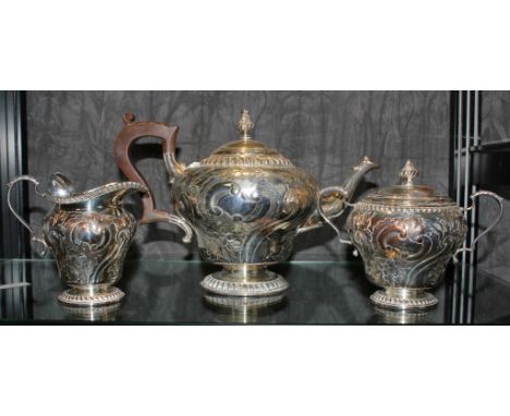 A Victorian silver plated tea service, to include tea pot, sugar bowl and jug with heavily embossed Rococo decoration (3)