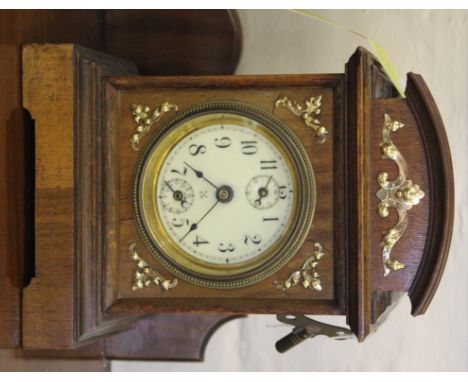 An Edwardian mahogany and walnut veneered mantle clock with shaped cornice, brass adornments, circular porcelain face with Ro