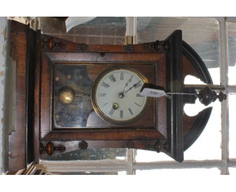 A late 19th century mahogany and walnut framed bracket clock with arched cornice and turned finial, circular dial with Roman 