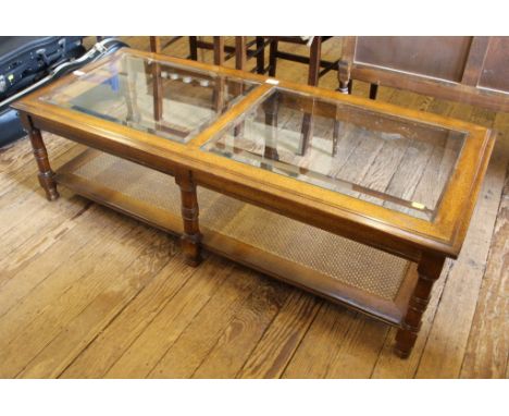 A mid 20th century French-style walnut coffee table of oblong form with glass top, shelf under with rattan surface, 38 H x 12