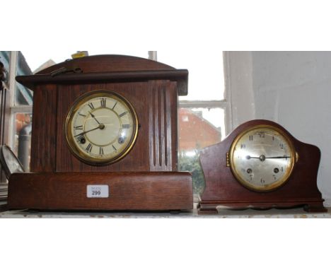 An early 20th century oak framed mantle clock with domed top, fluted supports, circular dial with Roman numerals by Waterbury