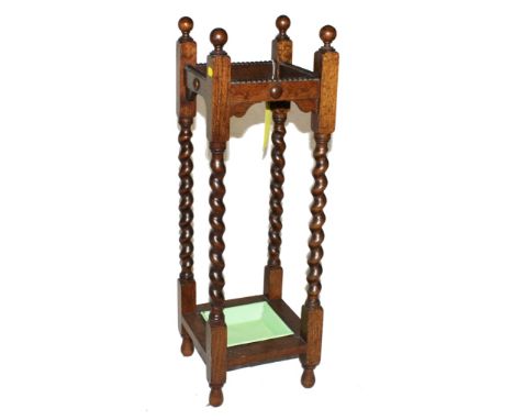 An Edwardian oak stick stand with spherical finials, rope twist supports with painted drip tray 78cm high