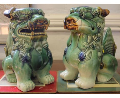 A pair of early 19th century Chinese ceramic sitting foo dogs, 26cm high