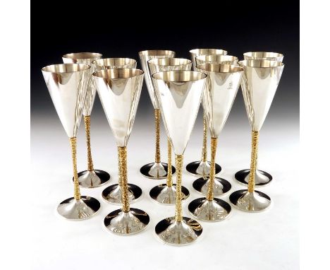 Stuart Devlin, a matched set of twelve Modernist silver and parcel gilt champagne flutes, London 1977 to 1980, the plain coni