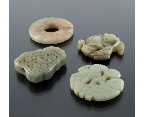 Four Chinese carved jade pendants, some reticulated, including an incised ring medallion, figures and animals, 5.5cm (4)
