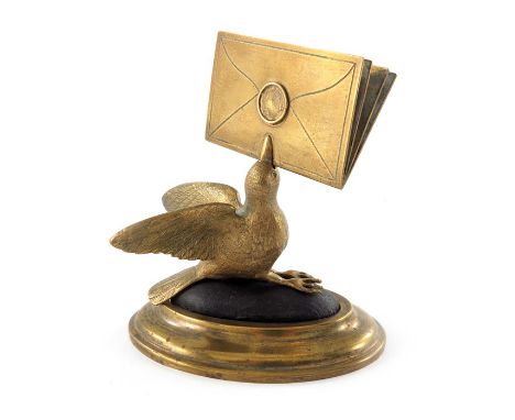A gilt brass figural letter holder, 19th century, modelled as a bird with beak full of letters, on a pin cushion and stepped 