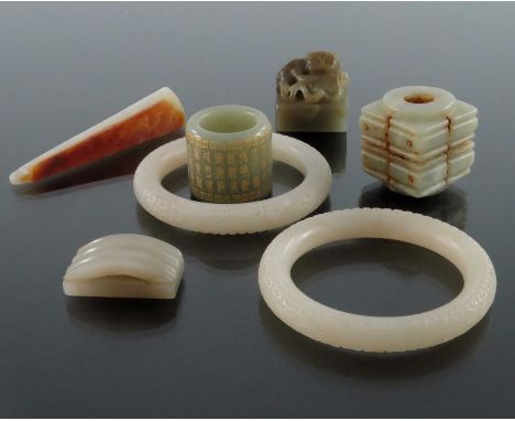 A collection of Chinese jade and hardstone carvings, including archers ring, bangles, seals etc., bangles 8cm diameter (7)