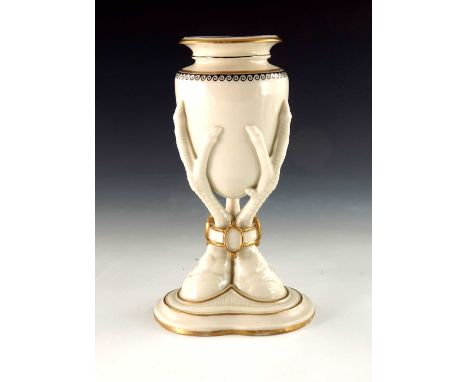 A Royal Worcester relief moulded vase, 1867, modelled as an amphora supported on three birds feet encircled by a bracelet wit