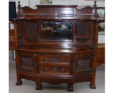 A large pollard oak Arts & Crafts mirror back sideboard with extensively carved panels, the raised back with moulded cornice 