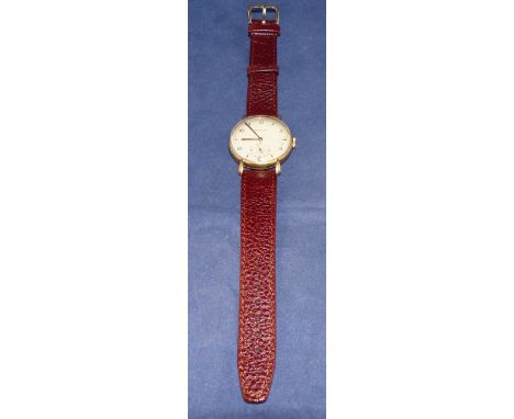 A gent's 9 carat hallmarked gold wristwatch by Jaeger-LeCoultre, with champagne dial and alternating Arabic numerals and butt