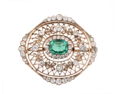 An emerald and diamond brooch, the pierced oval panel with a central emerald... An emerald and diamond brooch, the pierced ov