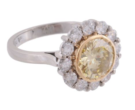 A yellow diamond and diamond cluster ring, the central yellow diamond  A yellow diamond and diamond cluster ring,   the centr