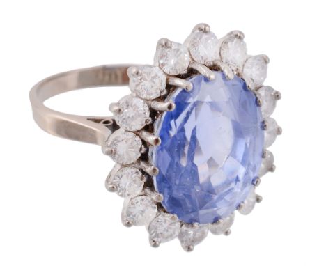 A sapphire and diamond cluster ring, the oval cut sapphire estimated to...  A sapphire and diamond cluster ring,   the oval c