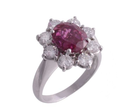 A ruby and diamond cluster ring, the central oval shaped ruby  A ruby and diamond cluster ring,   the central oval shaped rub