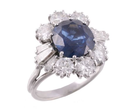 A sapphire and diamond cluster ring, the cushion shaped sapphire  A sapphire and diamond cluster ring,   the cushion shaped s