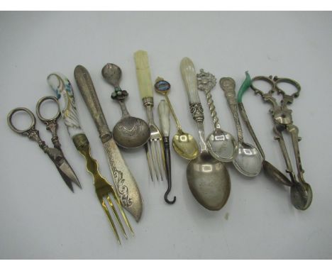 Collection of silver items including teaspoons, grape scissors, sugar nips, caddy spoon and a glove button hook with mother o