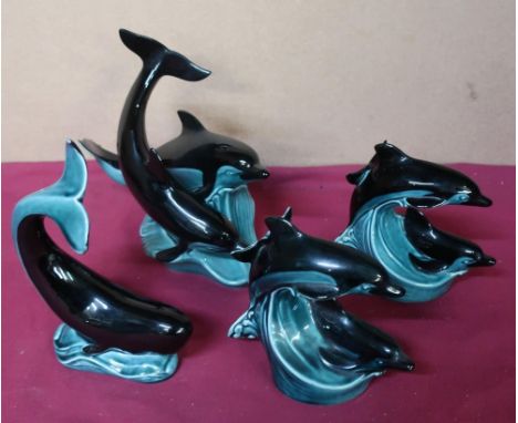 Poole Pottery twin dolphin figurines, one large and two small, and one figurine of a whale (4) 