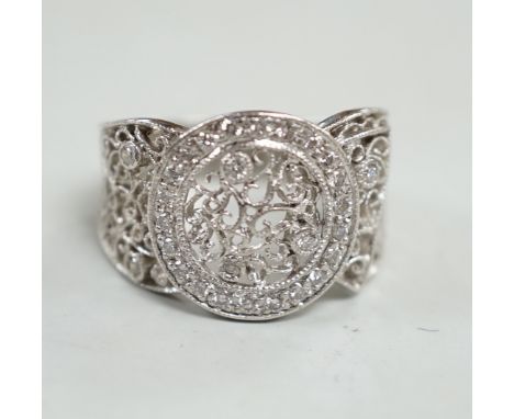 A pierced white metal and diamond chip set diamond ring, with scrolling decoration, size Q/R, gross weight 10.4 grams.