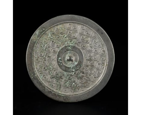 Miroir en bronze, Chine, dynastie Han, décor en relief de queues de taotie, bord lisse, diam. 8,6 cmProvenance: Hong Kong Coi