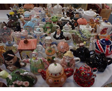 A COLLECTION OF NOVELTY CERAMIC TEAPOTSin the form of houses, shops, animals and characters etc
