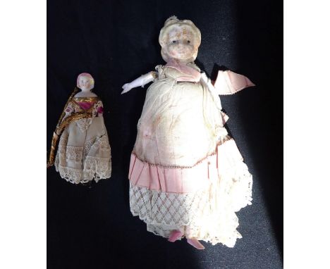 AN EARLY 19TH CENTURY WAX HEAD DOLLwith straw filled body, wooden arms and legs, (some damage) 24cm long. With a 19th century