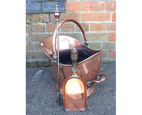A COPPER HELMET-SHAPE COAL SCUTTLEVictorian, with shovel and poker