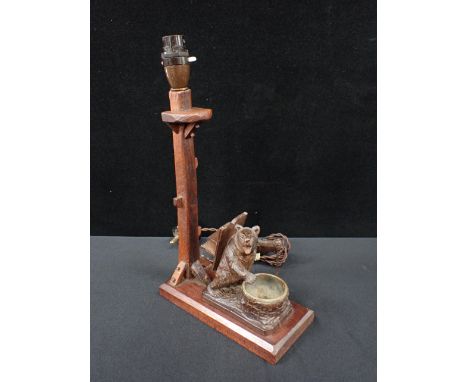 A BLACK FOREST BEAR MATCH HOLDER AND ASHTRAYlater mounted on an oak lamp base (untested)