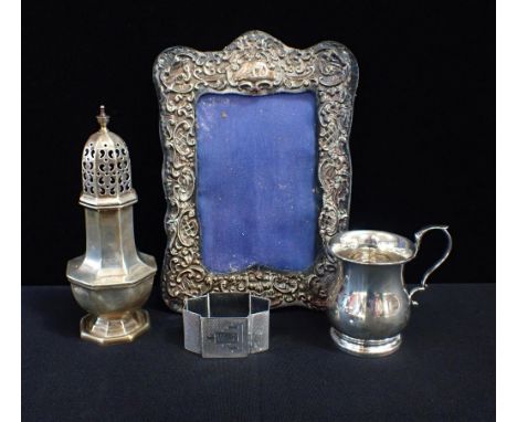 A SILVER SUGAR SIFTERwith a silver mug, napkin ring and picture frame (4)