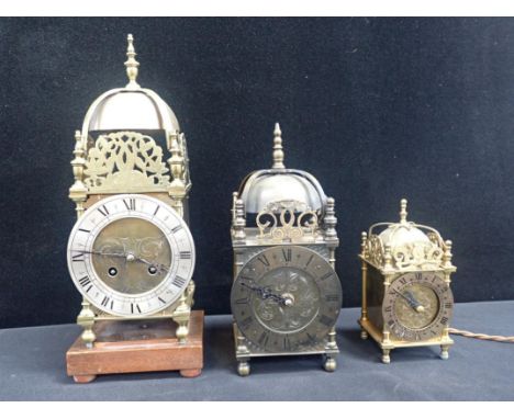 A REPRODUCTION BRASS LANTERN CLOCKwith Japy Freres movement, striking on a bell, 31cm high, with two other lantern style cloc