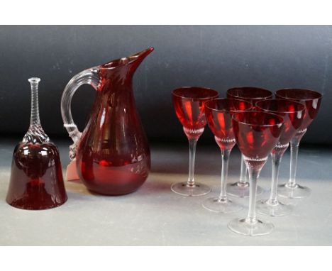 Whitefriars ruby red water jug with clear glass ribbed handle, 20cm high, together with a set of six red &amp; clear glass wi