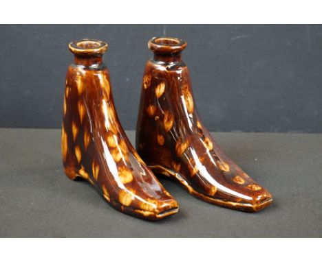 A pair of antique treacle glaze spirit flask bottles in the form of boots. 