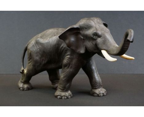 Japanese spelter figure of an Asian elephant, trunk raised, three character marks to base, approx 34cm long 