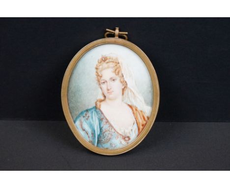 An antique hand painted miniature portrait of a female in traditional dress. 