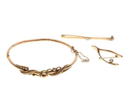 Diamond set wishbone design brooch stamped '10k', an unmarked bar brooch set single pearl, and a snap bangle, stamped '9ct', 