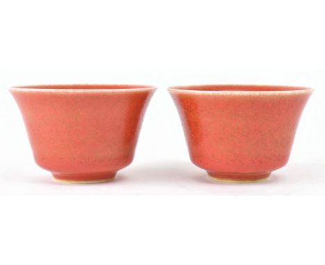 A pair of 20th century Chinese tea cups. Each cup decorated with coral red glazed, six characters "Kangxi" marked to the base