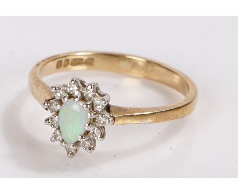 9 carat gold ring set with an oval opal surrounded by diamond chips, ring size L, 1.9g