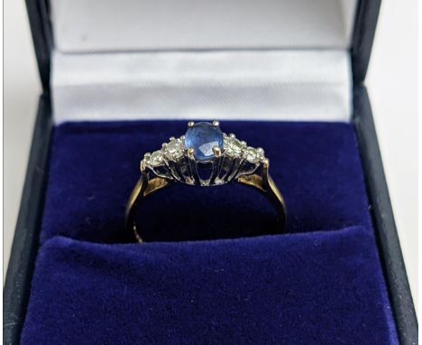 A 9CT YELLOW GOLD SAPPHIRE AND DIAMOND FIVE STONE RING, the central sapphire of 0.50 carat, the diamonds of 0.25 carats in to