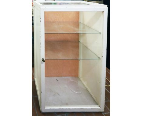 Kleine Vitrine. Geradliniger, 3-seitig eintürig verglaster, weiß gelackter Nadelholzkorpus. 2 Einlegeböden aus Glas. Alters- 