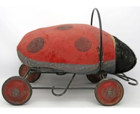 Reittier "Marienkäfer", Steiff. Stark abgeliebter Mohair. Schwarz gelacktes Metallgestell, rot gelackte Metallräder mit Gummi