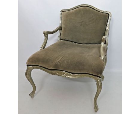 Fauteuil im Stil Louis XV. Vollflächig mit Metall verziertes Holzgestell. Graue Polsterung. Gebrauchsspuren. 20. Jh. H. 92 cm