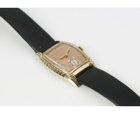Armbanduhr "BULOVA". Seitlich reliefiertes, tonnenförmiges Gehäuse 10 kt. goldfilled. Kupferfarbenes Zifferblatt mit aufgeleg