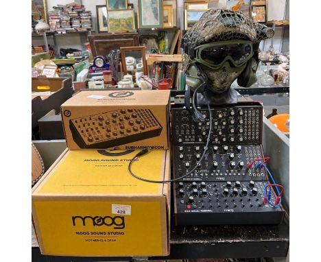 Sub Harmonican semi modular analogue synthesizer, a Moog percussion synthesizer along with a mannequin head with military gea
