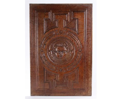Late 17th Century carved oak panel of a cherubs head, flanked by geometric patterns, 37cm x 56cm