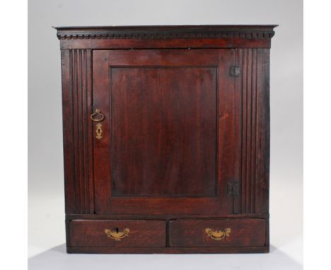 18th Century oak hanging cabinet, of large proportions, the cornice above a panel door flanked by grove sides and two small d