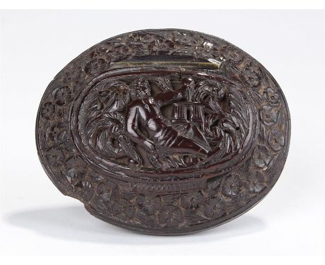 Late 18th Century carved coconut snuff box, deeply carved with a reclining figure clutching a goblet among thick leaves, the 