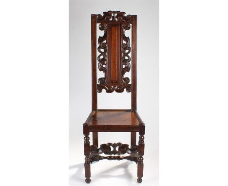 17th Century oak side chair, the carved and arched top rail above a panel back with further carved swags, with a solid seat a