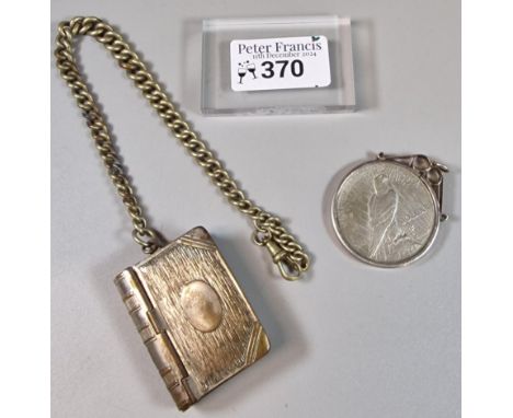 USA silver Dollar coin in pendant mount dated 1923, together with a silver plated vesta case in the form of a book with chain